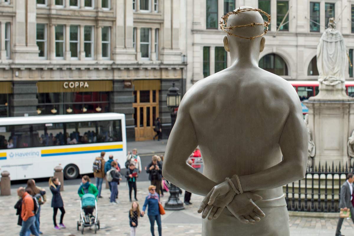 Mark Wallinger's Ecce Homo sculpture -life-size Christ-figure- viewed from behind, looking over London street