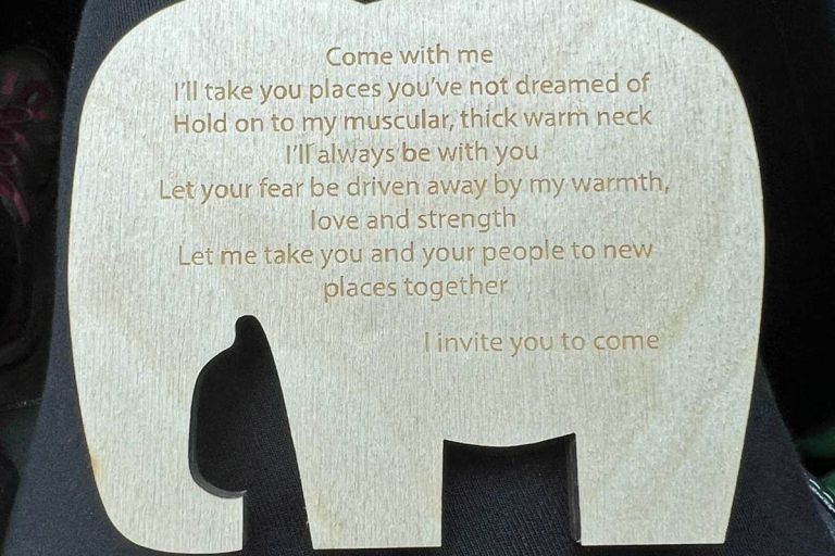 elephant-shaped piece of wood engraved with words of blessing