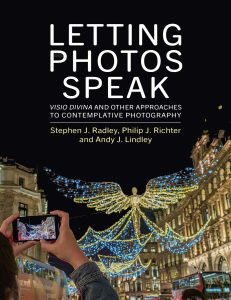 Book cover shows someone taking a smartphone image of Christmas lights in the form of a giant angel