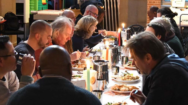 people gathered round a meal table in a church
