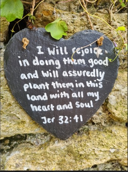 Heart shaped slate with verse from Jeremiah 32:41: I will rejoice in doing them good and will assuredly plant them in this land with all my heart and soul.