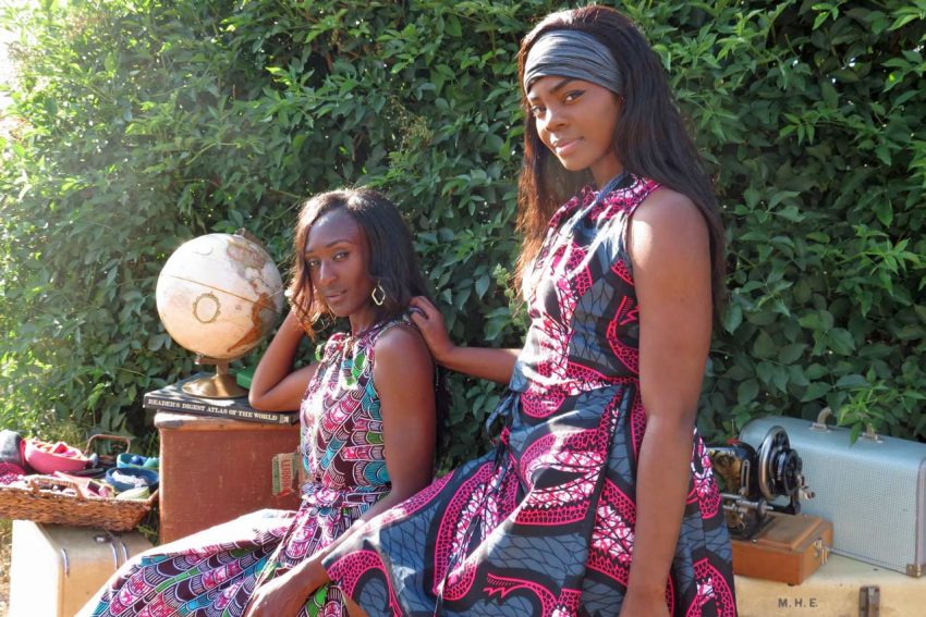 Young Black women model brightly patterned Dorcas dresses